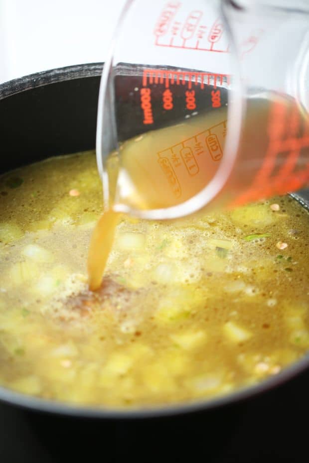 Adding vegetable stock to the soup